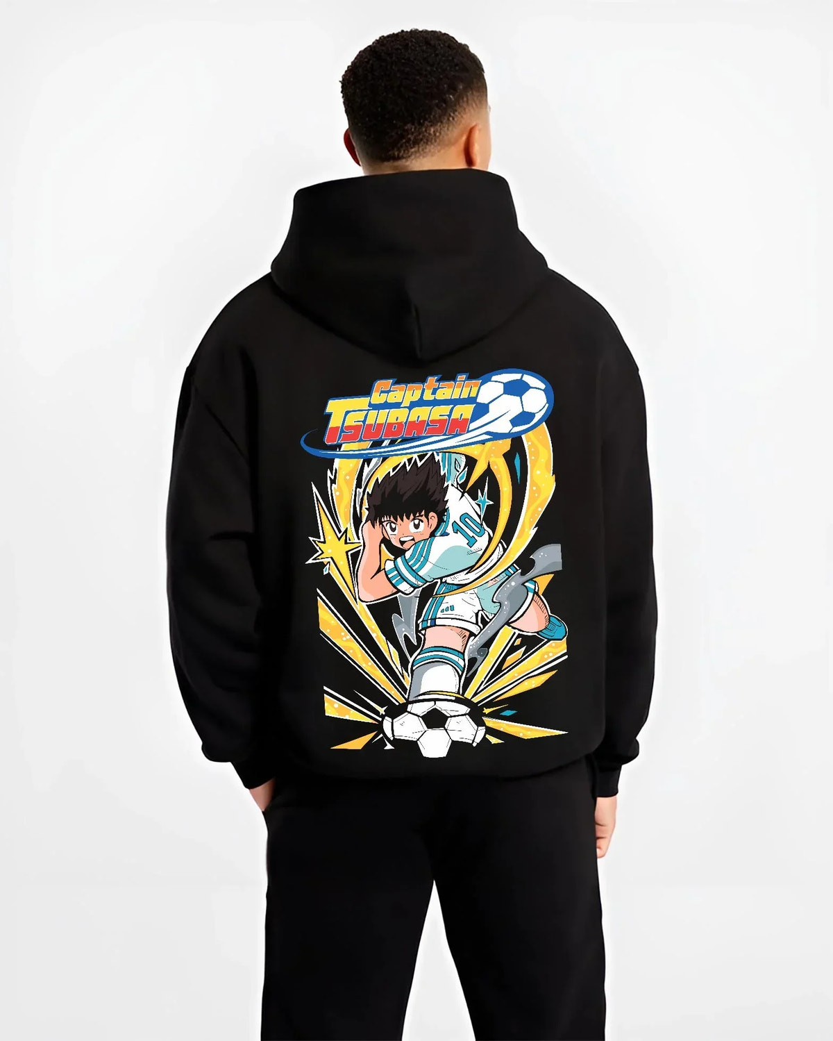 Black hoodie worn by male model, back view with Tsubasa Hoodie Captain Tsubasa Soccer Kick Classic graphic streetwear graphic.