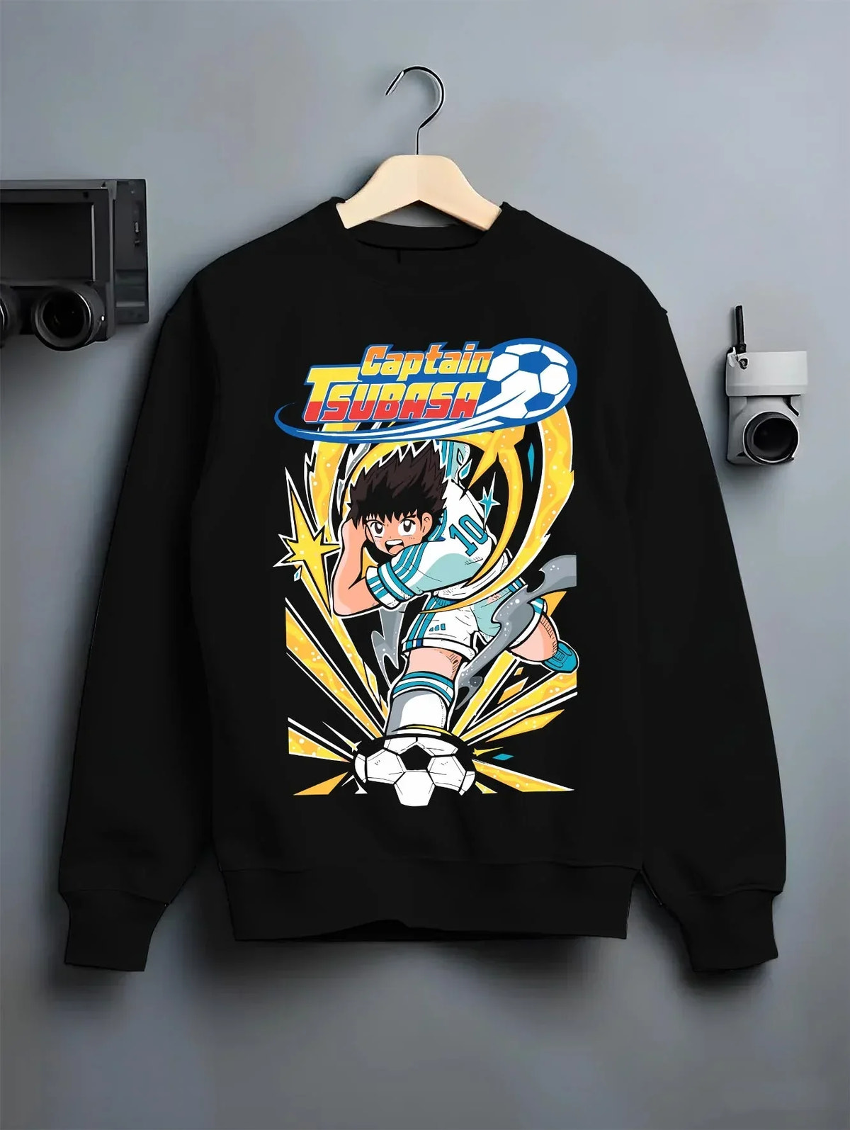 Black crewneck sweatshirt on hanger with Tsubasa Hoodie Captain Tsubasa Soccer Kick Classic graphic streetwear graphic.