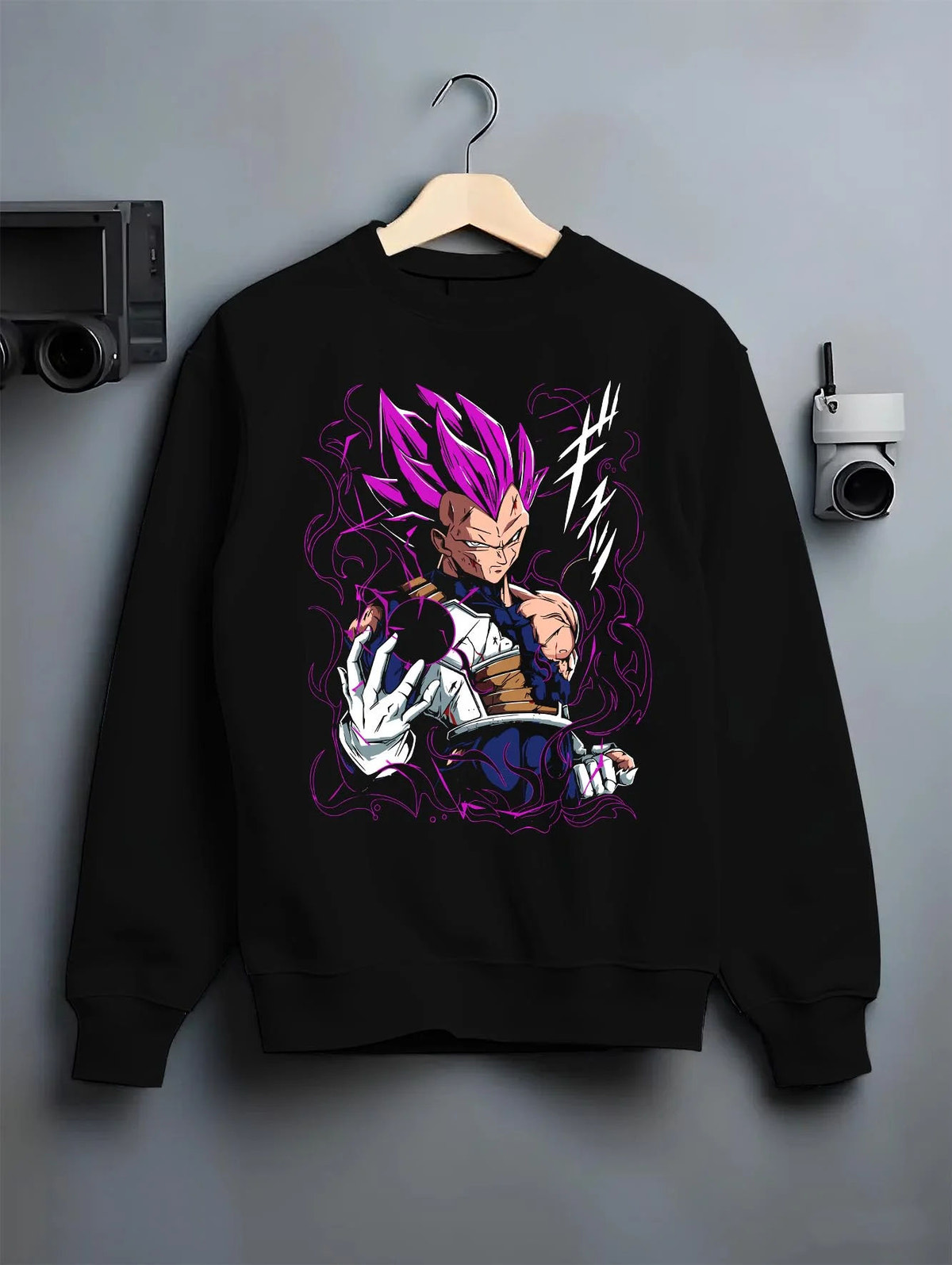 Black crewneck sweatshirt on hanger featuring Vegeta Ultra Ego purple aura battle Dragon Ball Super artwork.