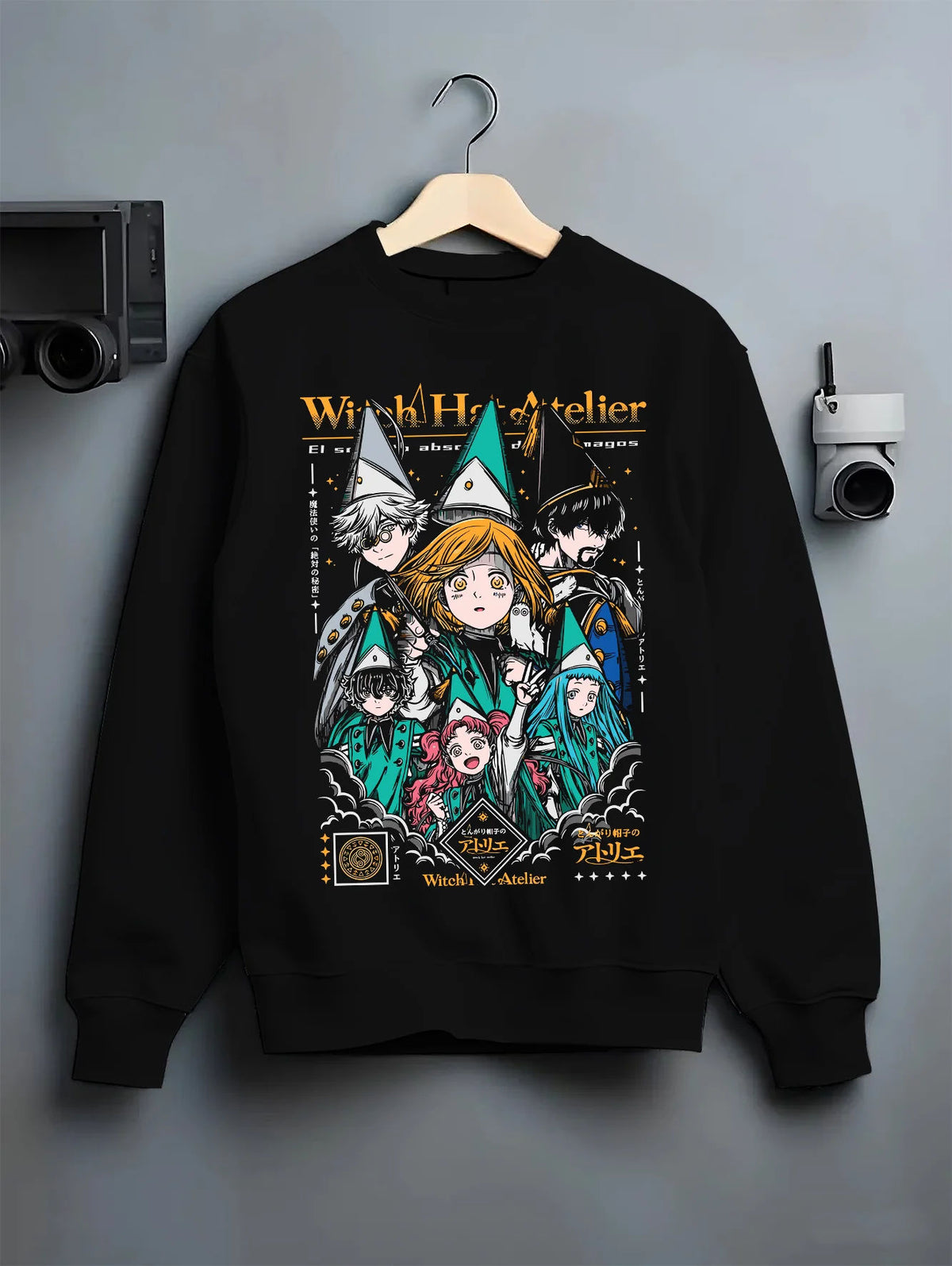 Black crewneck sweatshirt on hanger showing Witch Hat Atelier: magic student ensemble