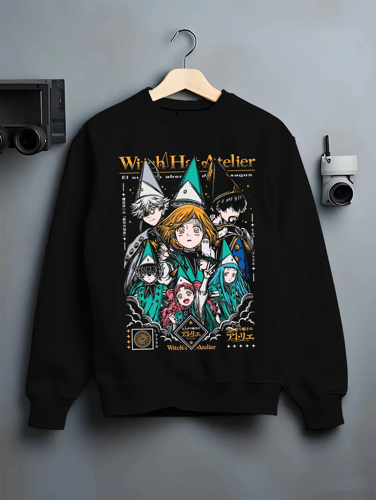 Black crewneck sweatshirt on hanger showing Witch Hat Atelier: magic student ensemble
