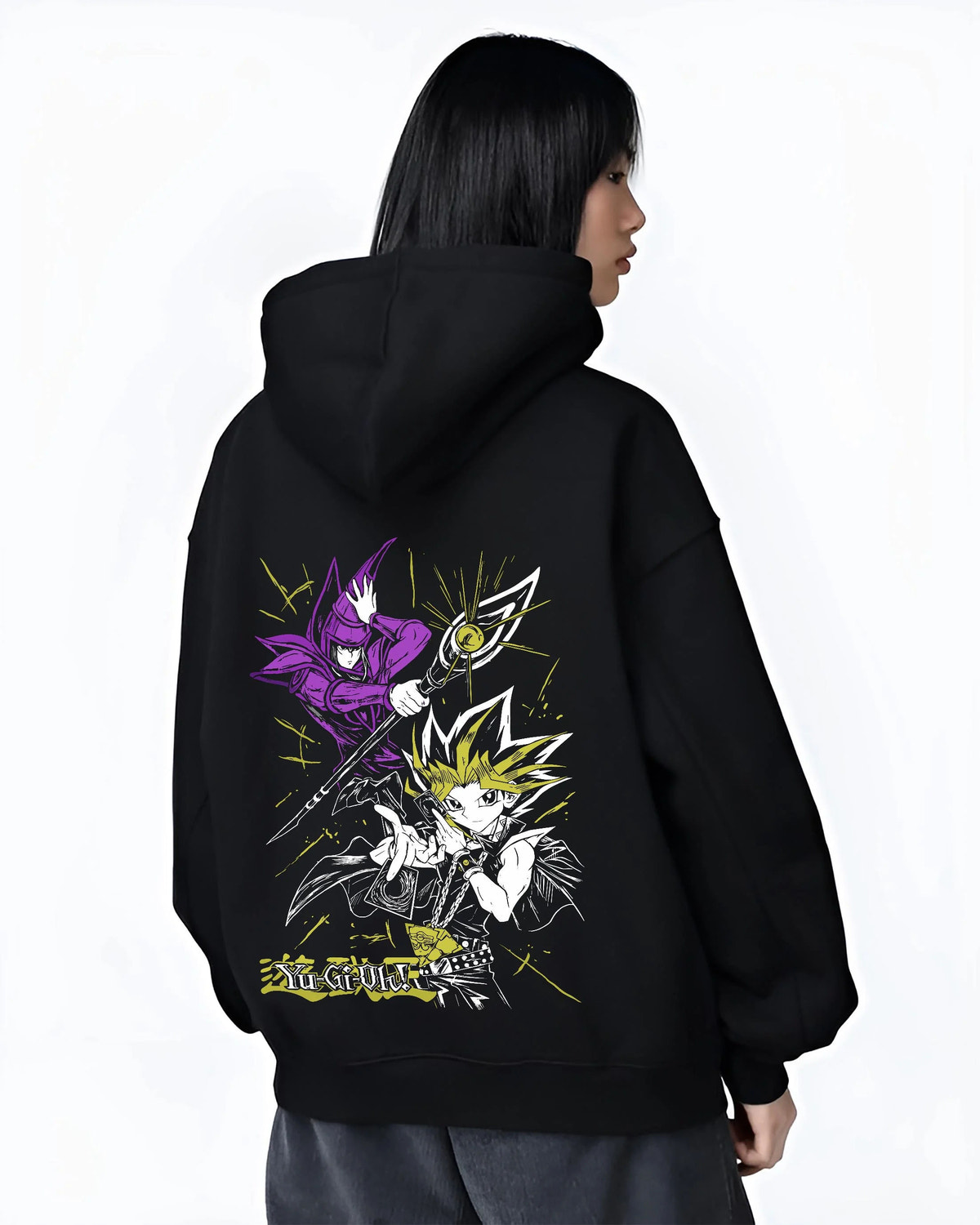 Black hoodie worn by female model from the back featuring Yugi Millennium Puzzle King of Games Yu-Gi-Oh! artwork.
