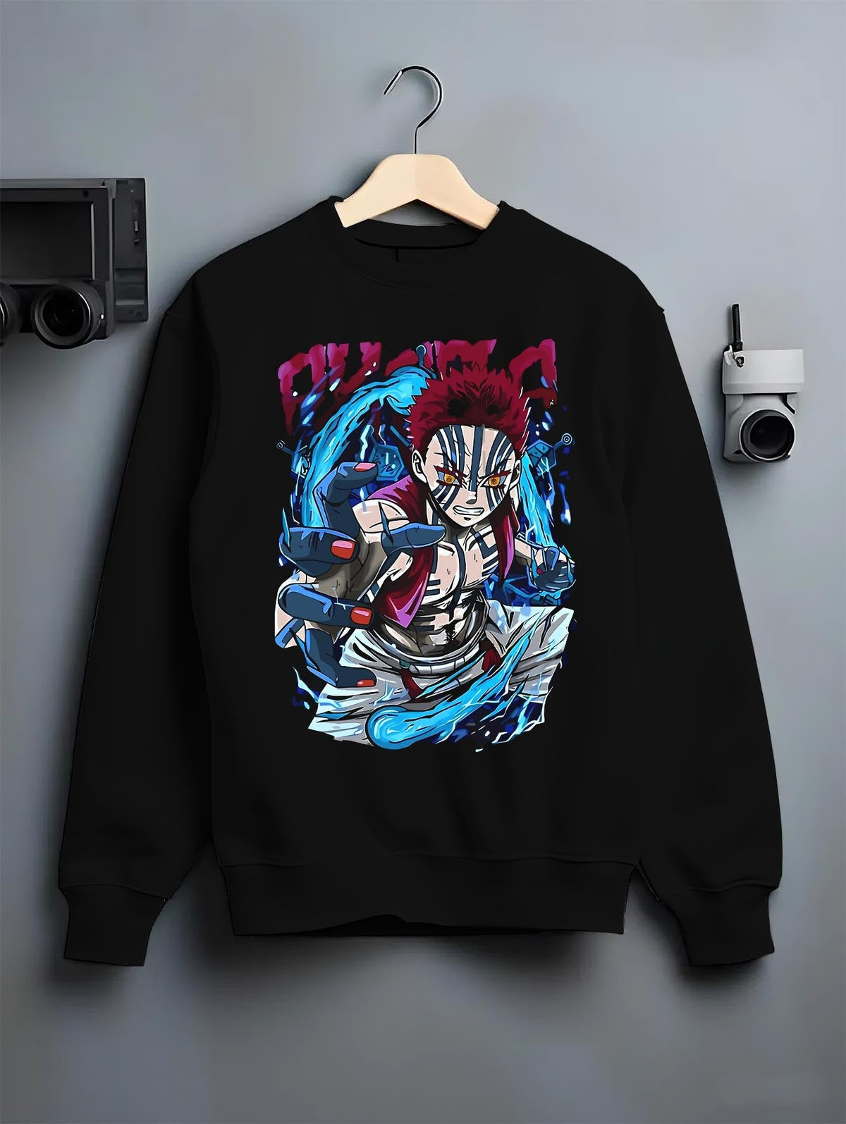 Black crewneck sweatshirt on a hanger against a grey wall, featuring Akaza Demon Slayer cyberpunk anime aesthetic graphic with glowing battle aura and sharp manga detail.