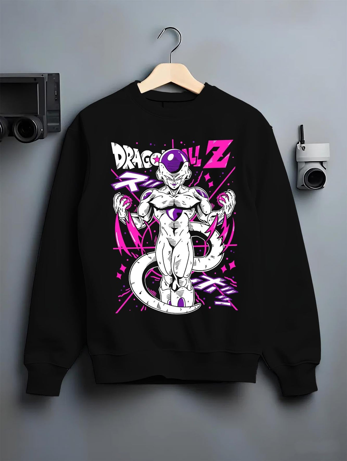 Black crewneck sweatshirt on a hanger against a grey wall, featuring Frieza Dragon Ball Z retro streetwear graphic with intense purple aura and vintage anime design.