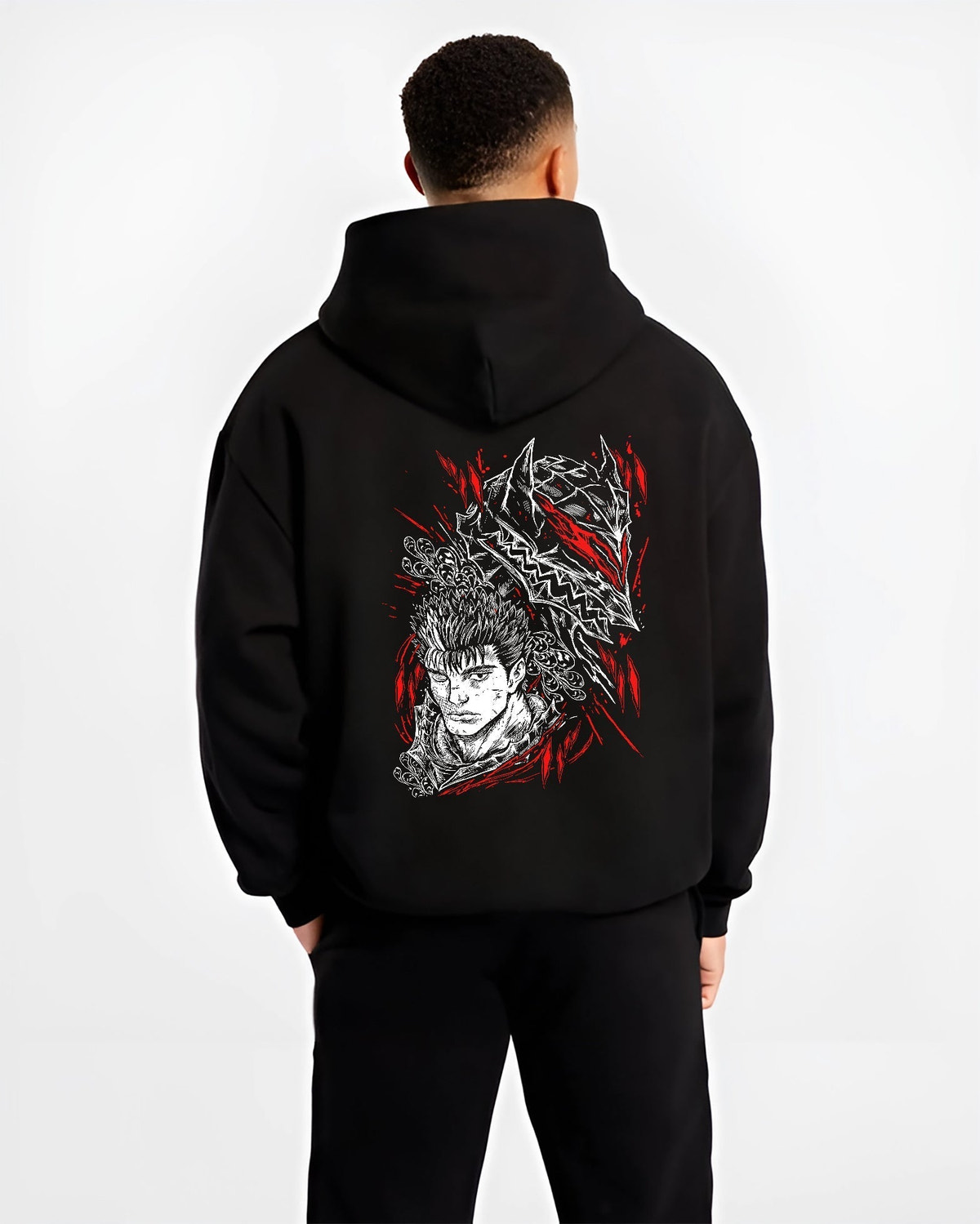 Black hoodie worn by a male model, back view, featuring Guts Berserk retro manga graphic with shonen battle character and dark fantasy-inspired artwork.