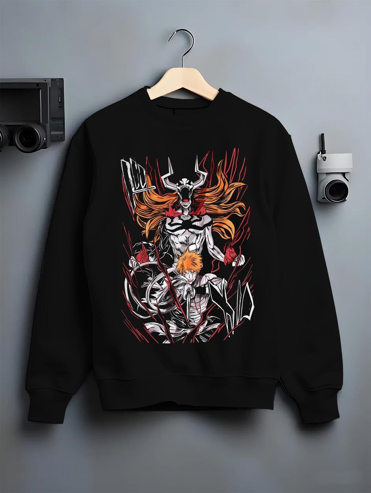 Black crewneck sweatshirt on a hanger against a grey wall, featuring Ichigo Bleach retro streetwear graphic with hollow transformation in bold dark manga panel style.