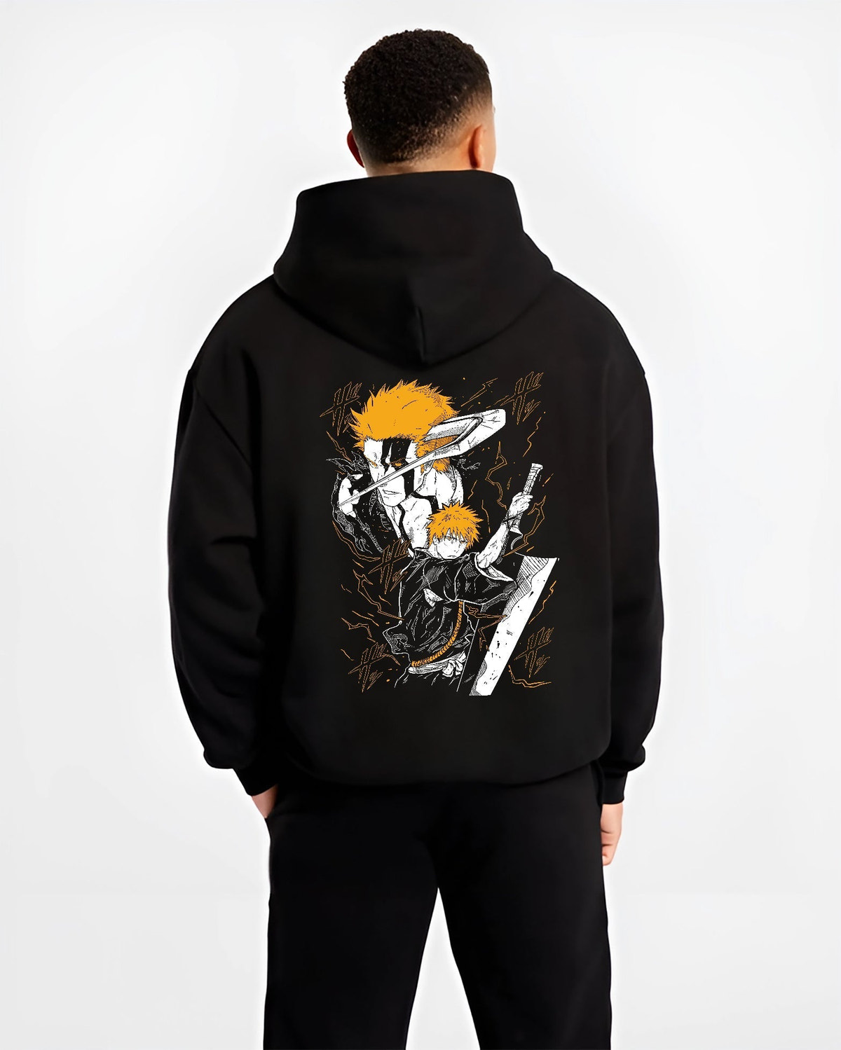 Black hoodie worn by a male model, back view, featuring Ichigo Bleach Japanese animation streetwear graphic with shonen battle character in striking orange sword pose.