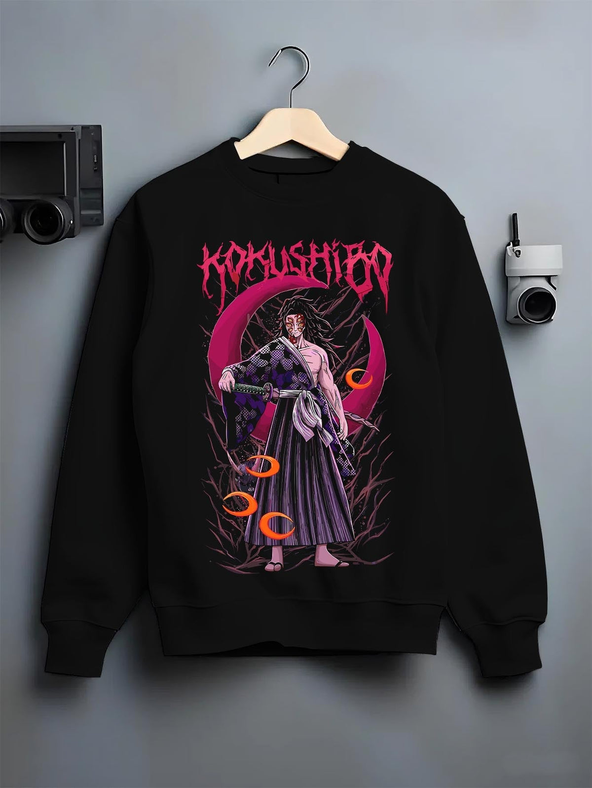 Black crewneck sweatshirt on a hanger against a grey wall, featuring Kokushibo Demon Slayer retro streetwear graphic with crimson moon and haunting dark manga detail.