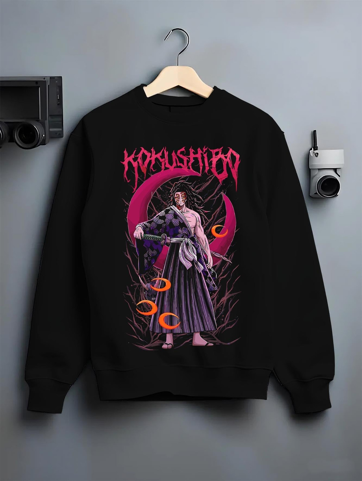 Black crewneck sweatshirt on a hanger against a grey wall, featuring Kokushibo Demon Slayer retro streetwear graphic with crimson moon and haunting dark manga detail.