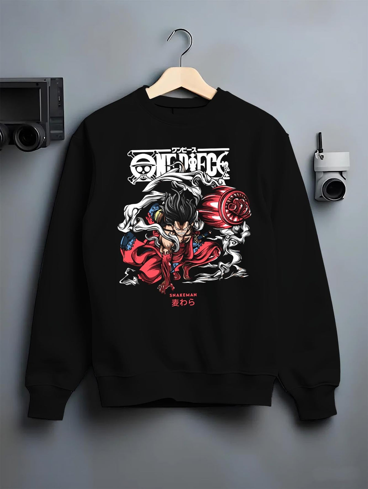 Black crewneck sweatshirt on a hanger against grey wall, featuring One Piece Luffy Snakeman urban fashion back graphic with smoke and red tones.
