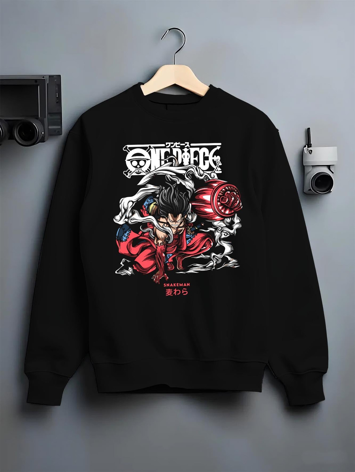Black crewneck sweatshirt on a hanger against grey wall, featuring One Piece Luffy Snakeman urban fashion back graphic with smoke and red tones.