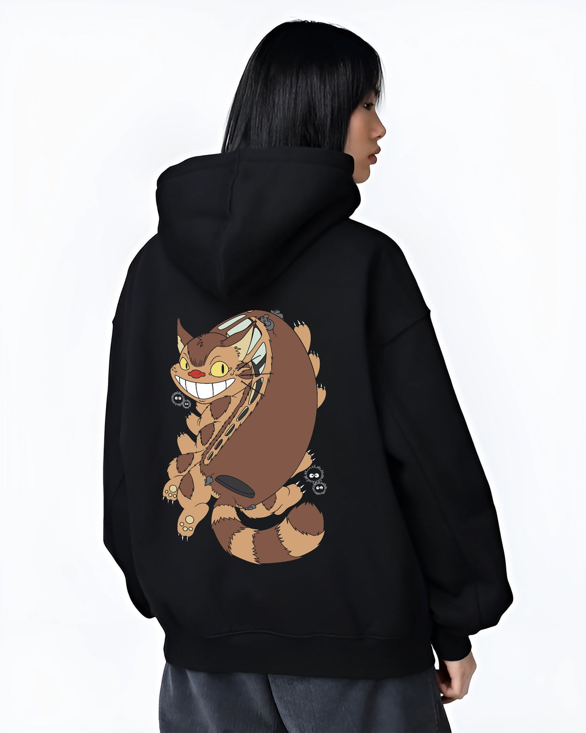 Black hoodie worn by a female model, back view, featuring Totoro Catbus and soot sprites; modern streetwear graphic with vintage retro touch.
