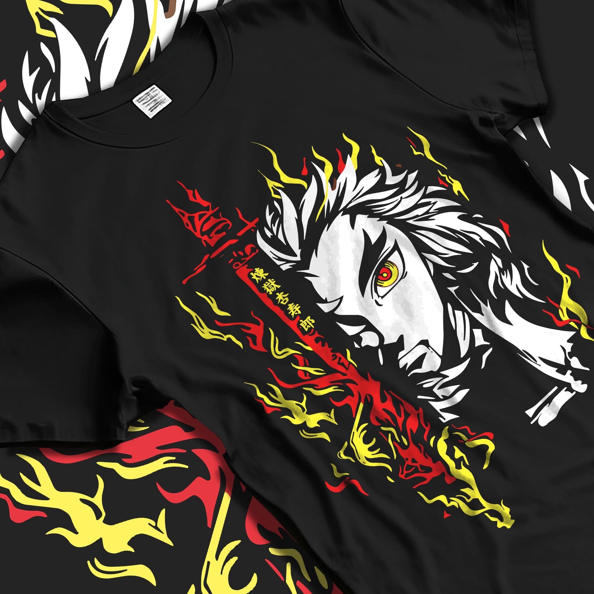 Black T-shirt laid flat with soft folds, featuring Rengoku anime poster inspired artwork with flaming sword and yellow-red fire accents.