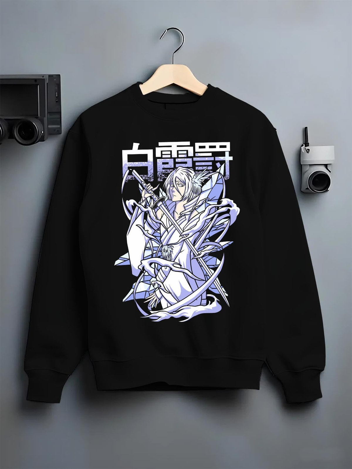 Black crewneck sweatshirt on a hanger against a grey wall, featuring Rukia Kuchiki Bleach Bankai icy retro manga poster inspired anime artwork