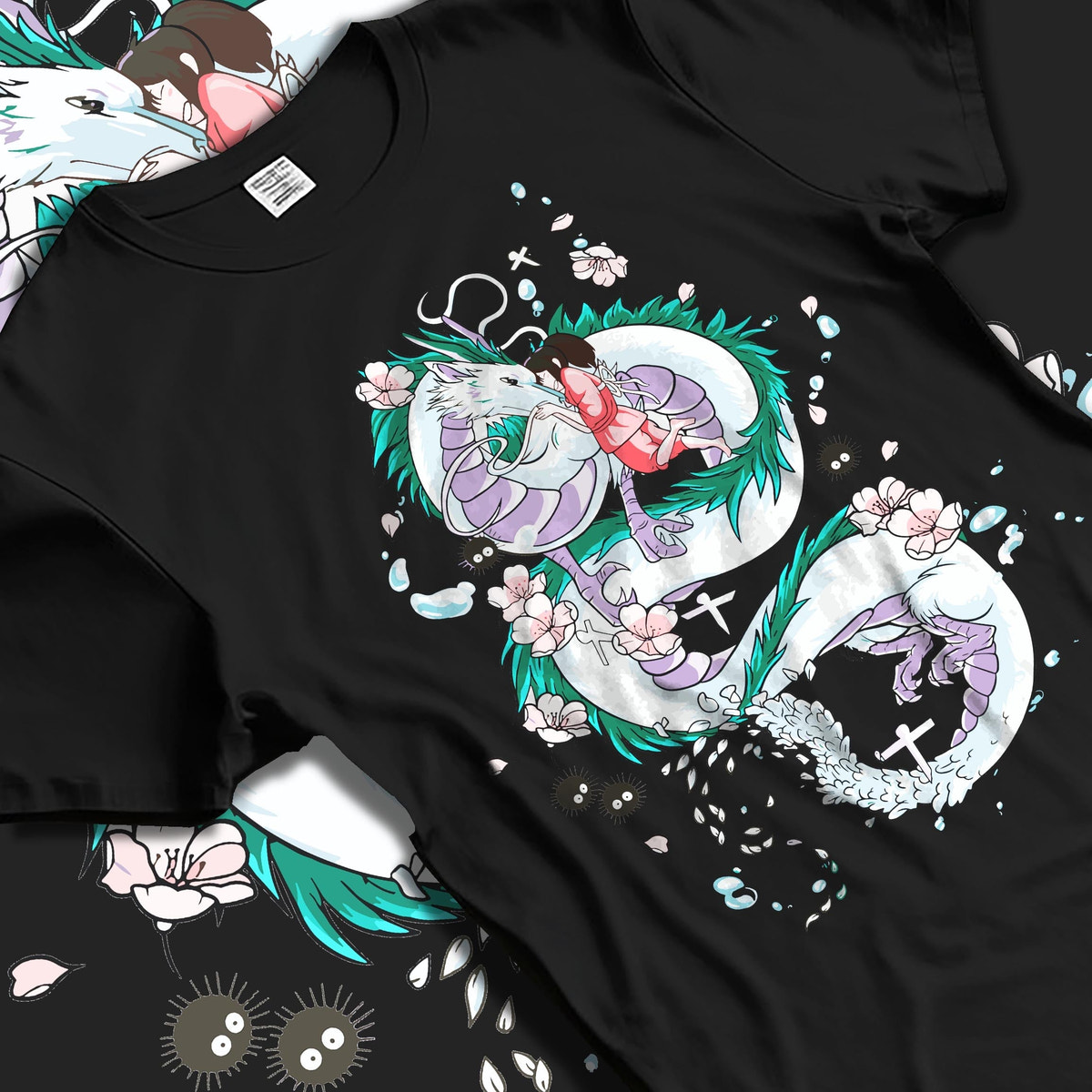 Black T-shirt laid flat with soft folds, featuring Spirited Away Haku dragon and Chihiro anime poster inspired design with blossoms.