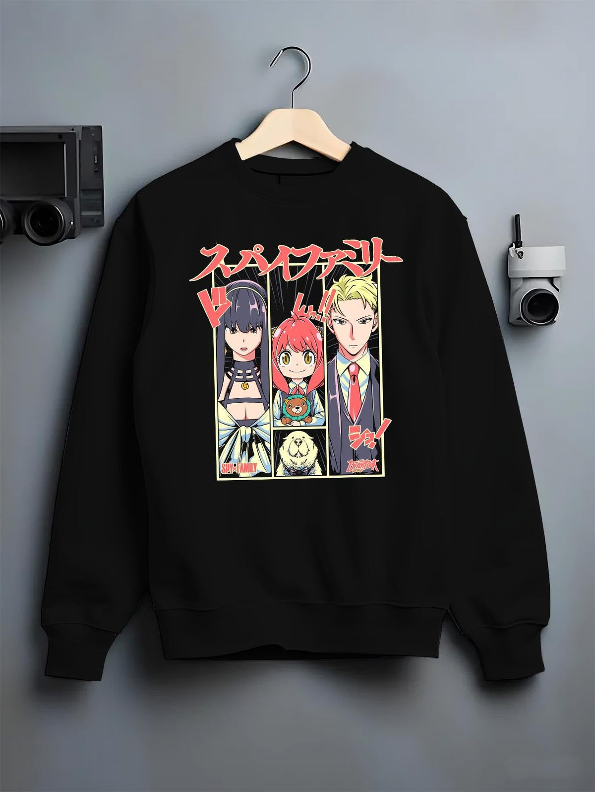 Black crewneck sweatshirt on hanger against grey wall, Spy x Family trio panel back graphic with Japanese text.