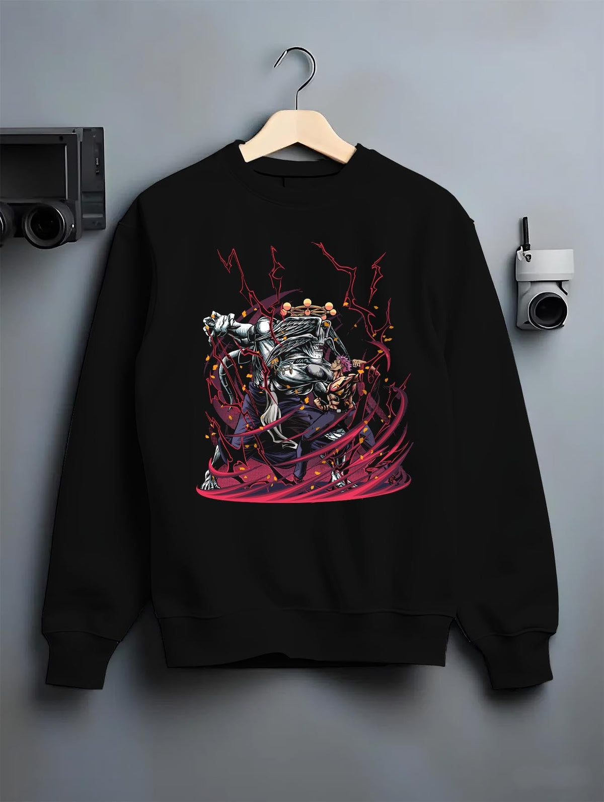 Black crewneck sweatshirt on hanger against grey wall, Sukuna vs Mahoraga anime poster back graphic with intense red energy.