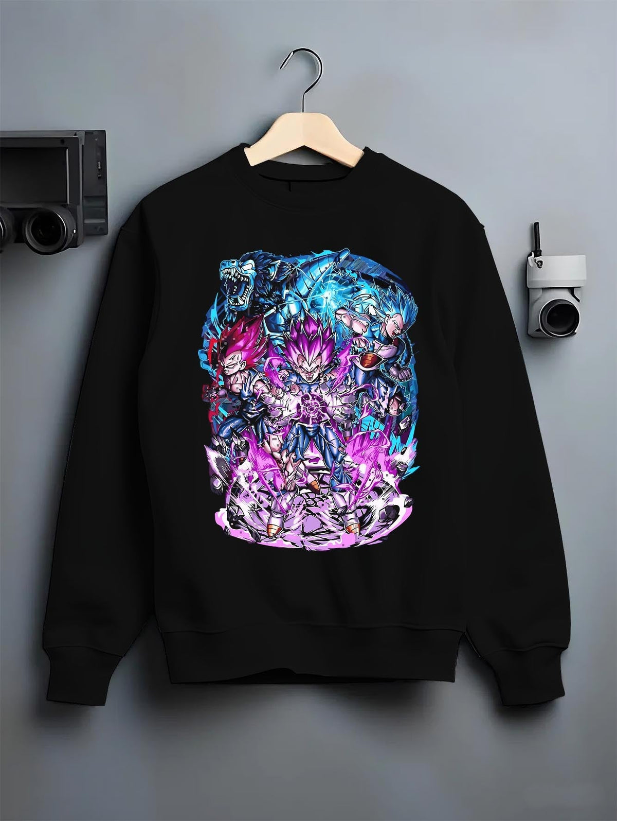 Black crewneck sweatshirt on a hanger against a grey wall, featuring Vegeta Dragon Ball retro streetwear graphic with electrifying purple aura and bold manga details.
