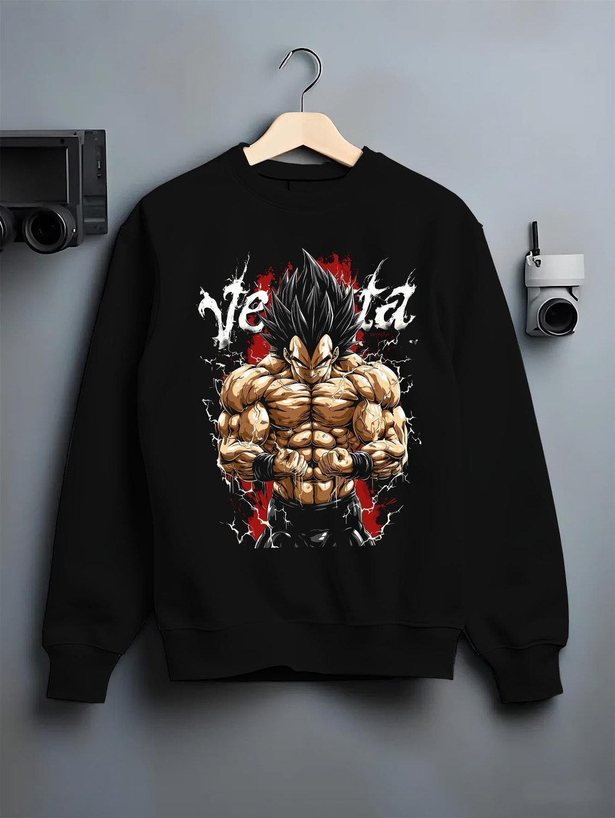 Black crewneck sweatshirt on a hanger against a grey wall, featuring Vegeta Dragon Ball Z anime poster inspired back design with bold shonen battle graphic artwork.