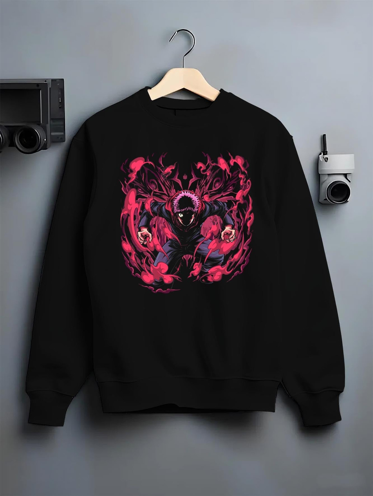 Black crewneck sweatshirt on hanger against grey wall, Yuji Itadori anime poster back graphic with bold red cursed aura.