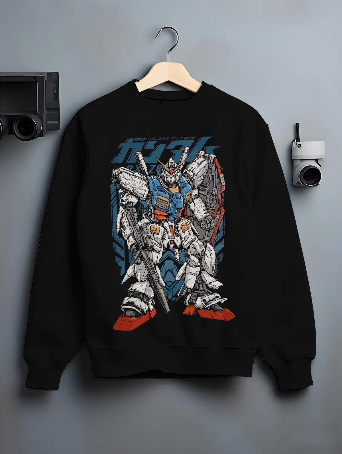 Black crewneck sweatshirt on a hanger against a grey wall, featuring Zeta Gundam anime poster inspired retro mecha artwork styled in nostalgic manga panel graphic